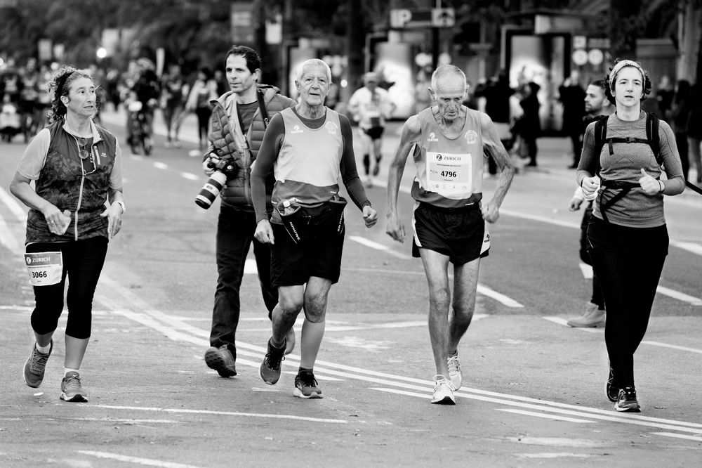 Older runners taking part in a road race, in black and white